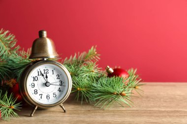 Ahşap masa renk arka plan üzerinde çam dalları ile çalar saat. Noel geri sayım
