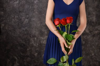 Kadınla koyu arka plan karşı güzel kırmızı gül buketi
