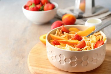 Çilek ve şeftali ahşap tahta üzerinde kase lezzetli mısır gevreği