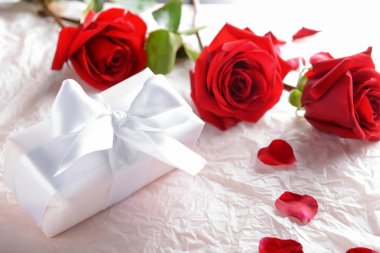 Güzel kırmızı gül ve kağıt ambalaj üzerinde hediye kutusu