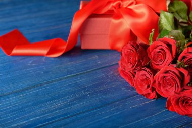 Güzel kırmızı gül ve hediye kutusu ahşap arka plan üzerinde