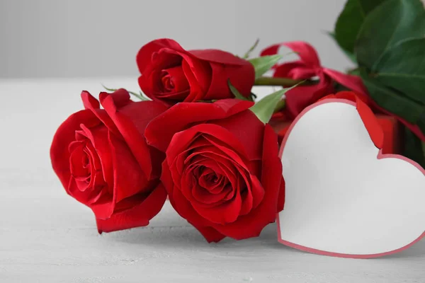 Πανέμορφα Κόκκινα Τριαντάφυλλα Και Κενή Κάρτα Στο Φως Τραπέζι — Φωτογραφία Αρχείου