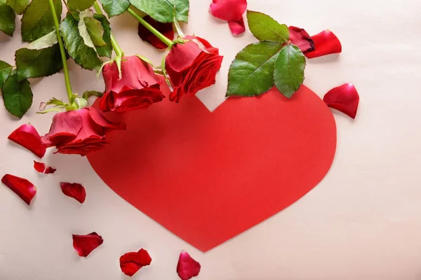 Πανέμορφα Κόκκινα Τριαντάφυλλα Και Χαρτί Καρδιά Επάνω Ελαφρύς Υπόβαθρο — Φωτογραφία Αρχείου