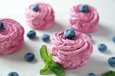 Beyaz masa üzerinde yaban mersini ile lezzetli zephyr