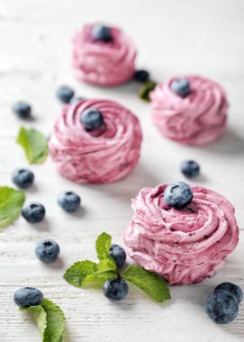 Beyaz masa üzerinde yaban mersini ile lezzetli zephyr