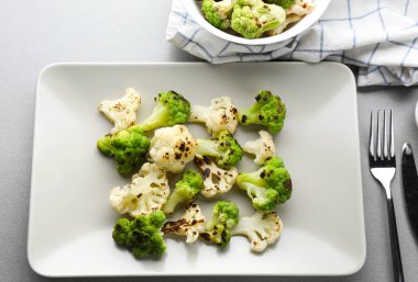 Plakalı gri masada renkli karnabahar