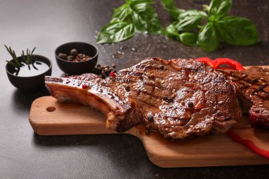 Ahşap tahta ile karanlık masada lezzetli ızgara biftek