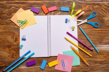 Açık defter ile ahşap arka plan üzerinde okul kırtasiye