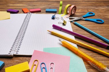 Açık defter ile ahşap arka plan üzerinde okul kırtasiye