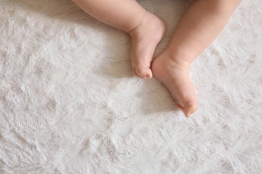 Yatakta uzanmış şirin küçük bebek bacakları