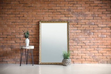 Tuğla duvar odadaki yakınındaki yeşil bitkiler ile büyük şık ayna