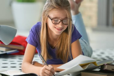 Şirin kız öğrenci ödev kapalı yerde yatarken süre