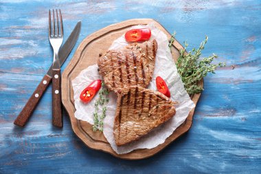 Kurulu lezzetli ızgara biftek, kekik ve ahşap masa üzerinde kesme biber ile