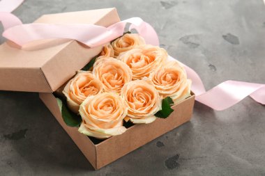 Hediye kutusu gri masaya güzel çiçek ile