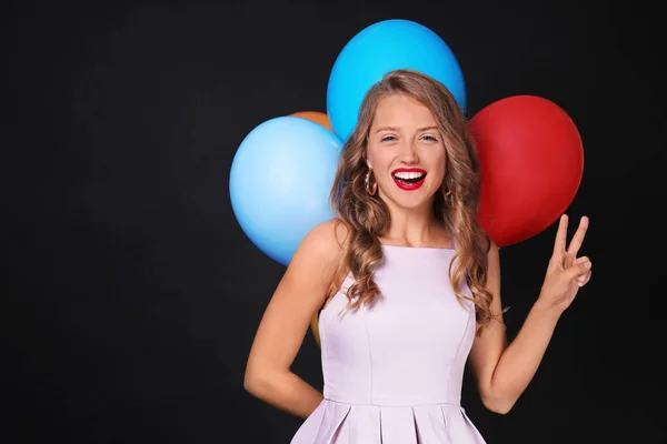 Schöne Junge Frau Mit Luftballons Mit Siegesgeste Auf Dunklem Hintergrund — Stockfoto