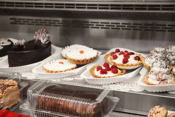 Refrigerated display case with delicious desserts in supermarket