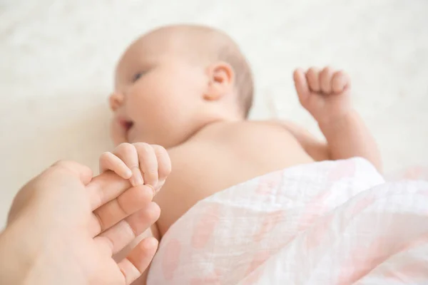 Bonito Bebê Segurando Mão Mãe Enquanto Deitado Cama — Fotografia de Stock