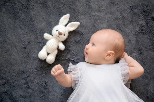 可爱的小婴儿与兔子玩具躺在床上 顶部视图 — 图库照片