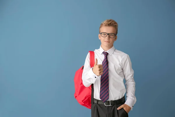 带背包的少年男孩在彩色背景上显示拇指向上的手势 — 图库照片