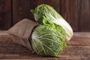 Ahşap masa üzerinde olgunlaşmış taze lahana ile çuval