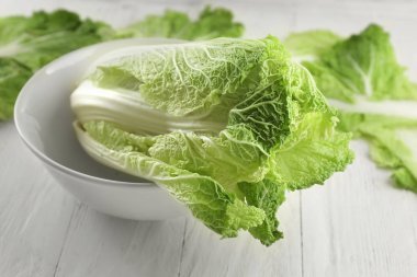 Hafif ahşap masa üzerinde olgunlaşmış taze lahana ile kase