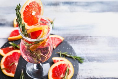 Taze greyfurt kokteyl cam kayrak plaka üzerinde rosemary ile