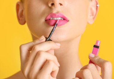 Güzel genç kadın parlak pembe ruj rengi arka planda, closeup uygulama