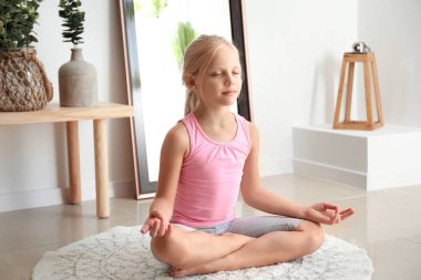 Küçük kız evde yoga uygulamak