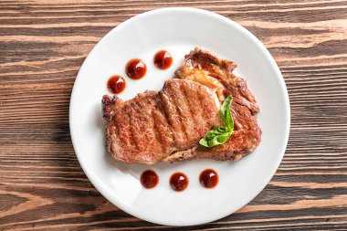 Plaka lezzetli ızgara biftek ve ahşap masa sosu ile