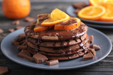 Lezzetli çikolatalı krep tatlı sos ve plaka üzerinde dilimlenmiş portakal ile