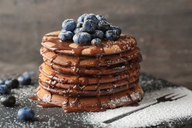 Lezzetli çikolatalı krep kayrak plaka üzerinde bir yaban mersini ve tatlı sos ile