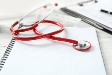 Sağlık stetoskop ve dizüstü Beyaz ahşap zemin üzerinde