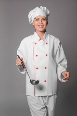 Gri arka plan üzerinde genç kadın şef