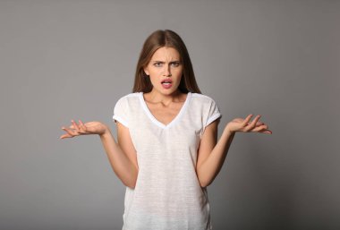 Gri zemin üzerine kızgın genç kadın