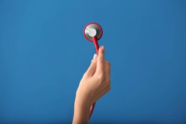 Kardiyolog renk arka plan üzerinde sağlık stetoskop ile el