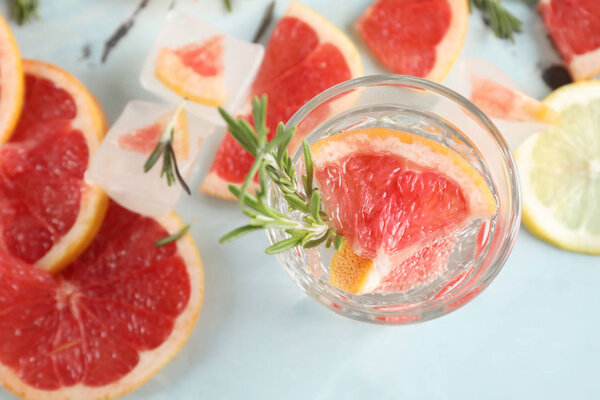 Fresh grapefruit cocktail with rosemary in glass on light table
