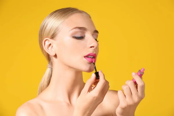 Hermosa Mujer Joven Aplicando Lápiz Labial Rosa Brillante Sobre Fondo —  Fotos de Stock