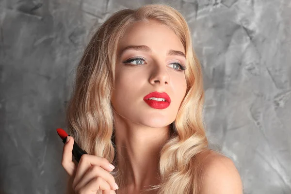 灰色の背景に鮮やかな赤い口紅と美しい若い女性 — ストック写真