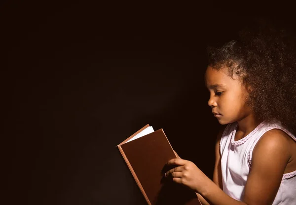 Niña Afroamericana Leyendo Libro Sobre Fondo Oscuro — Foto de Stock