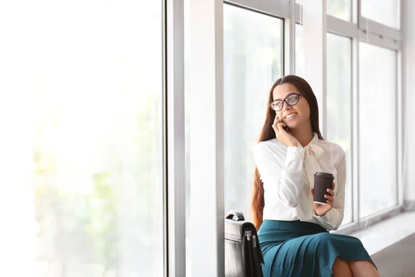 Genç Işkadını Pencere Pervazına Ofiste Otururken Telefonla Konuşuyor — Stok fotoğraf
