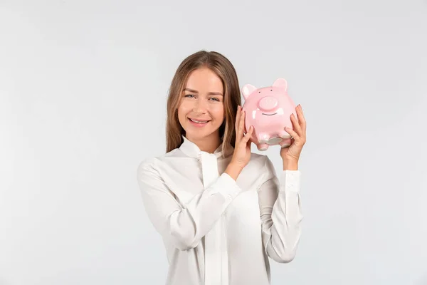 Mujer Joven Feliz Con Alcancía Sobre Fondo Claro —  Fotos de Stock