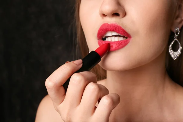 Schöne Junge Frau Die Knallroten Lippenstift Auf Dunklem Hintergrund Aufträgt — Stockfoto