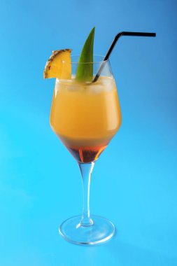 Lezzetli taze ananas mavi arka plan üzerinde kokteyl bardak