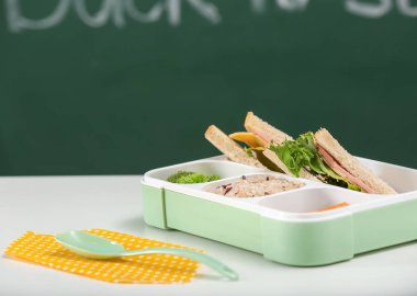 Öğle yemeği kutusu beyaz masasına iştah açıcı yemek ile