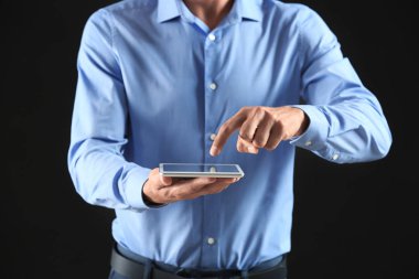 İşadamı ile tablet Pc koyu arka plan üzerinde
