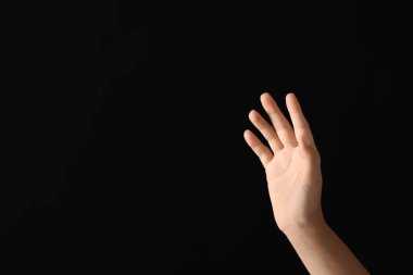 Koyu arka plan üzerinde sanal ekran kullanan genç kadın