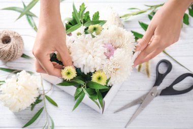 Masaya güzel papatya çiçek kutusuyla hazırlanıyor çiçekçi