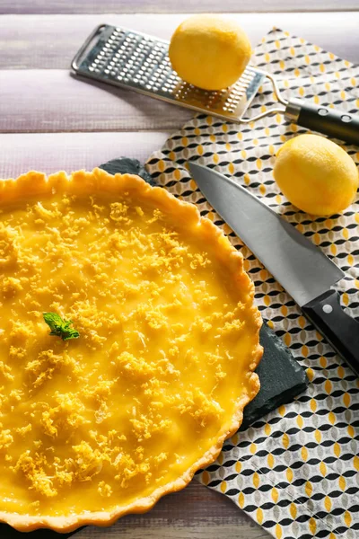 Ahşap masa üzerinde lezzetli limon pasta ile kayrak plaka