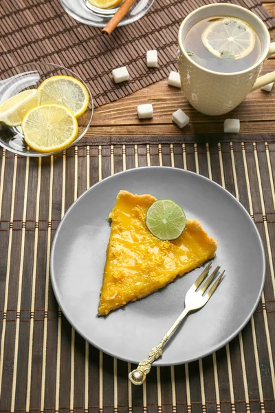 Plate with piece of delicious lemon pie on table