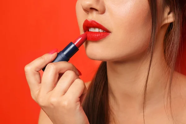 Όμορφη Νεαρή Γυναίκα Εφαρμογή Κόκκινο Κραγιόν Στο Φόντο Χρώμα Closeup — Φωτογραφία Αρχείου